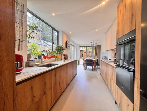 Completed Bermondsey kitchen looking through to the dining space, with Ballerina wood cabinetry and Dekton worktops