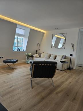 Completed open-plan living space in a Revivio flat refurbishment, with engineered flooring and integrated lighting
