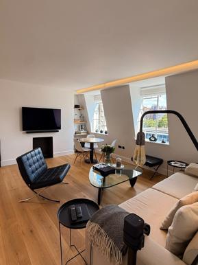 Open-plan living space in a completed Revivio flat refurbishment, with engineered flooring and a dining area by the window
