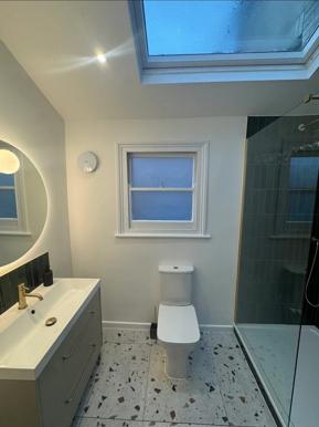 Completed Peckham bathroom with tiled walls, glass shower screen and vanity unit