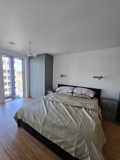 Dalston bedroom after renovation with fitted wardrobe and balcony doors