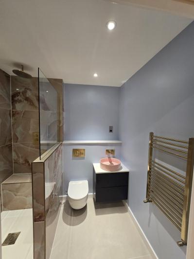 Stratford en-suite with marble-effect tiling, pink countertop basin and gold fittings