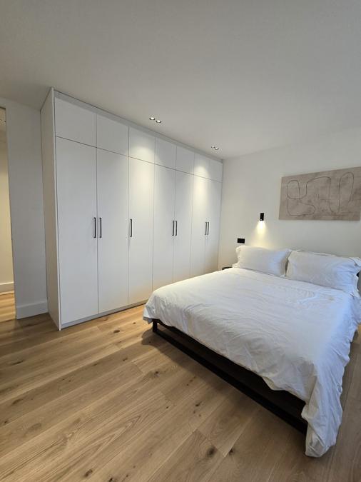 Bedroom in the Marylebone flat with bespoke built-in storage and a rooflight