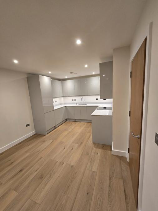 New kitchen fitted during the Stratford flat refurbishment, with grey cabinetry and a stone worktop