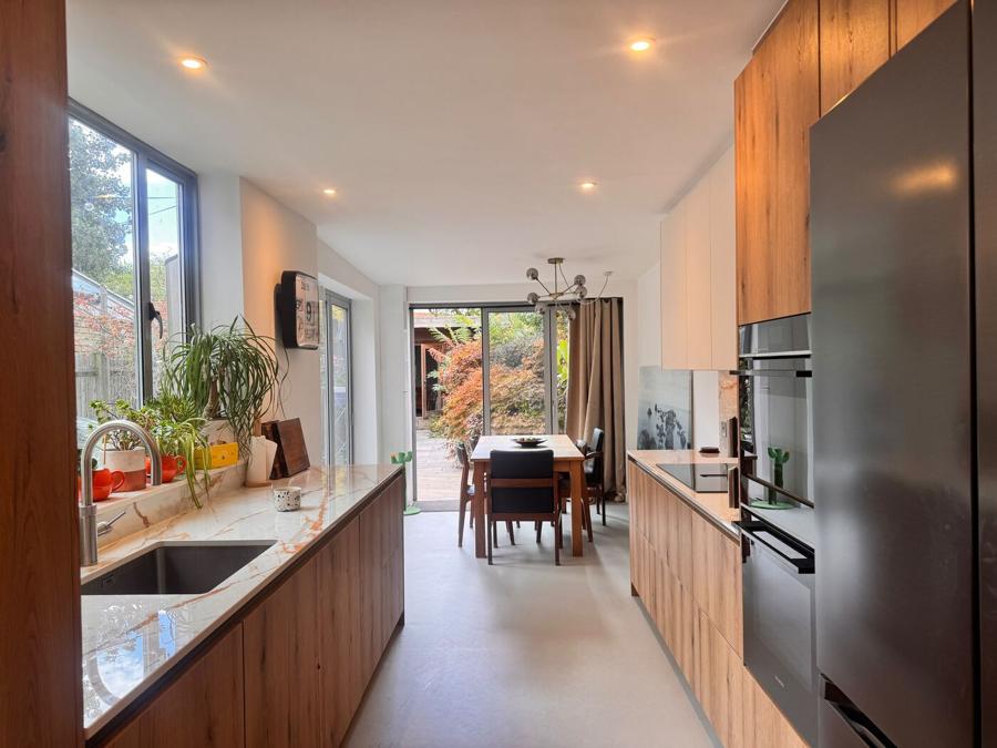 Dining end of the Bermondsey kitchen with the table, pendant light and garden doors, vinyl flooring running through