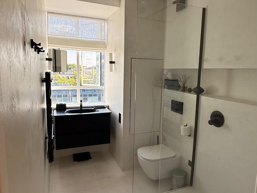 Second view of the Marylebone bathroom showing the vanity and glass shower screen
