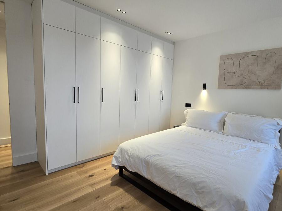 Bedroom in the Marylebone flat with bespoke built-in storage and a rooflight