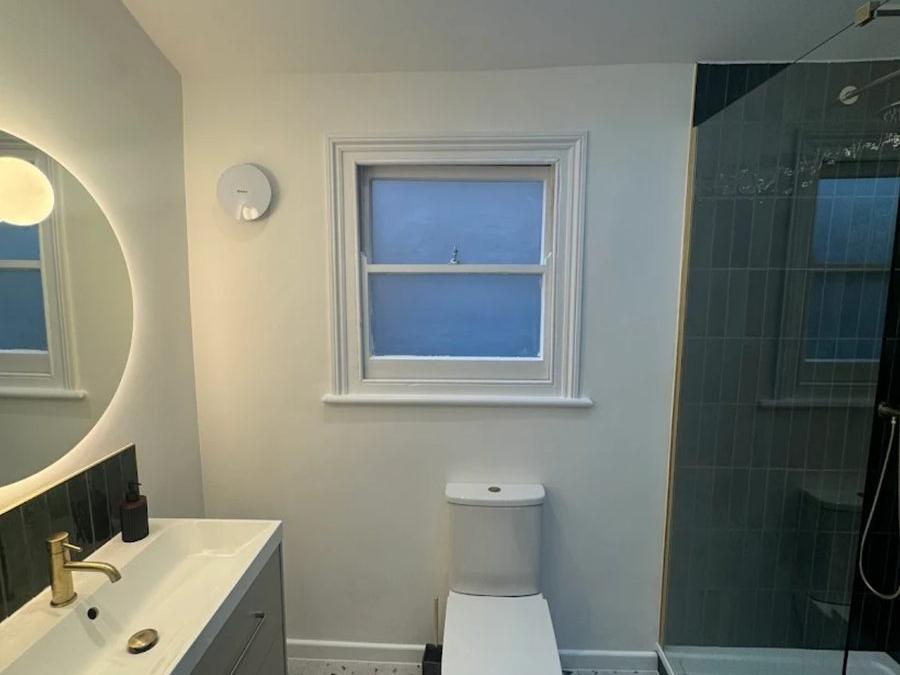Peckham bathroom renovation with green metro tiling and terrazzo-effect flooring