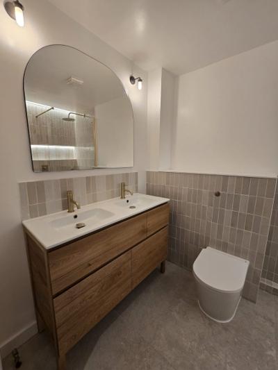 Rotherhithe second bathroom with double basin oak vanity, gold fittings and arched mirror