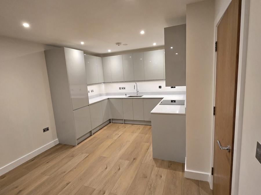 New kitchen fitted during the Stratford flat refurbishment, with grey cabinetry and a stone worktop