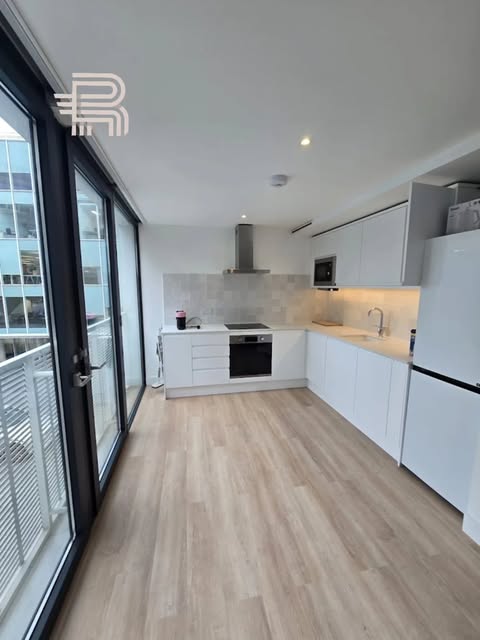 Battersea kitchen renovation with white cabinetry, wood flooring and balcony doors