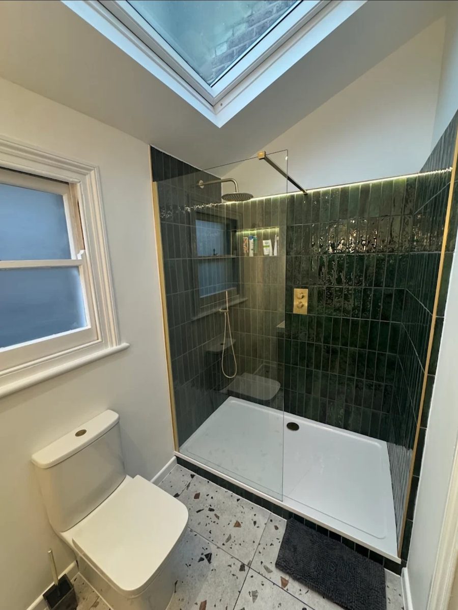 Peckham bathroom second angle showing green metro-tiled shower with gold fittings